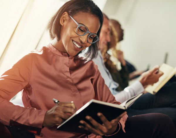 smiling-african-businesswoman-taking-notes-during-2021-08-26-17-26-49-utc