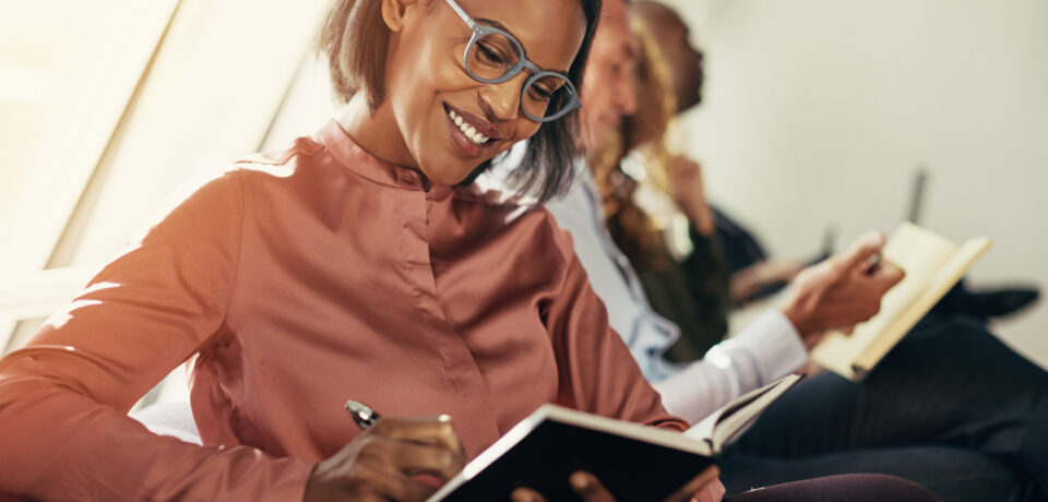 smiling-african-businesswoman-taking-notes-during-2021-08-26-17-26-49-utc